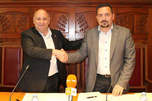 El alcalde de CiU, Francesc Colomé firmando el acuerdo con Juan Antonio Corchado (PSC)
