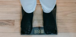 crop obese person standing on weighing scale