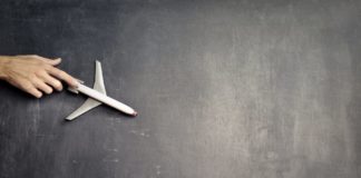 anonymous person with miniature airplane on chalkboard