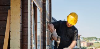 man in black long sleeve shirt holding yellow and black power tool